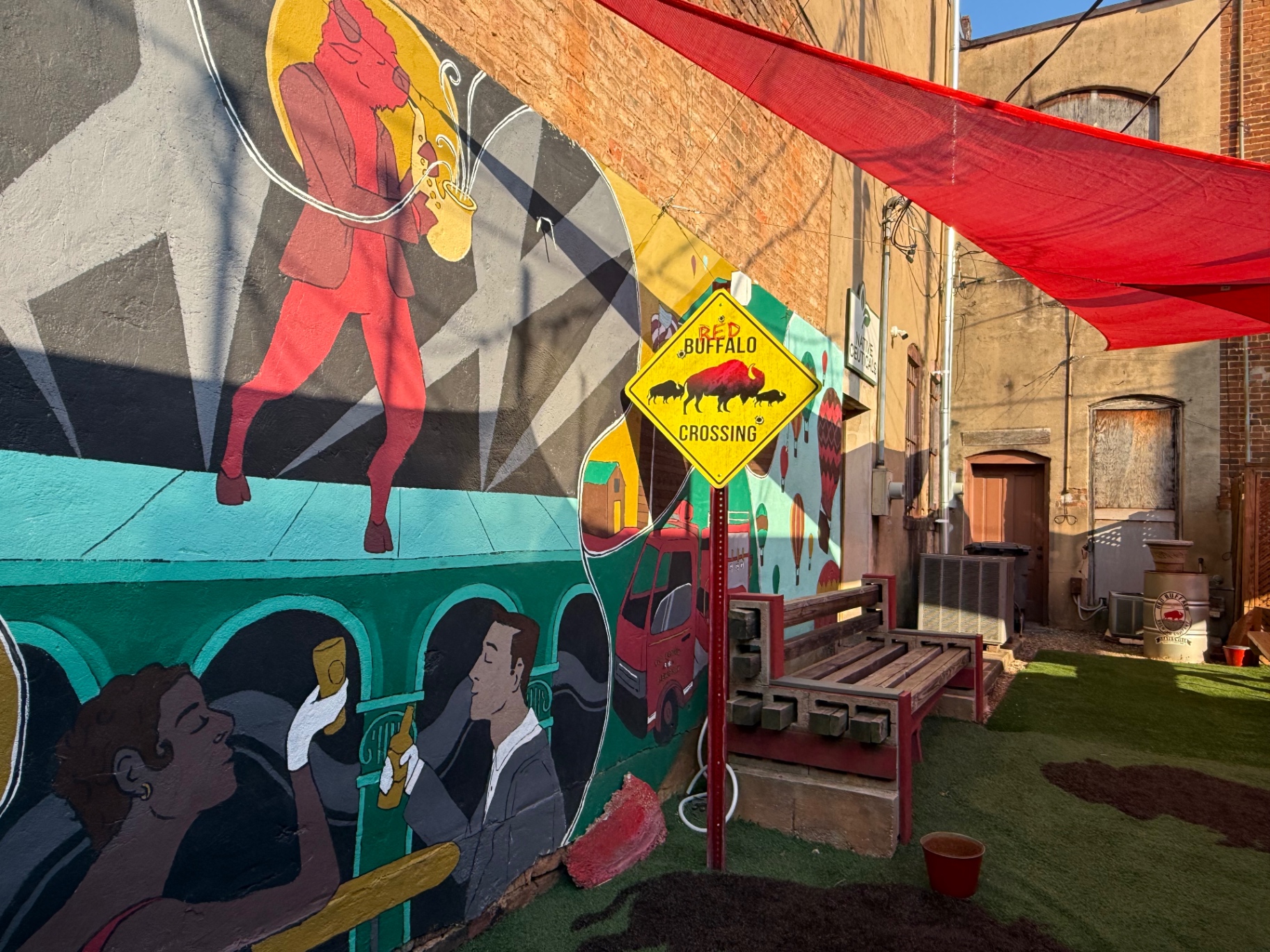 Red Buffalo Crossing sign and colorful mural in the brewery's outdoor patio